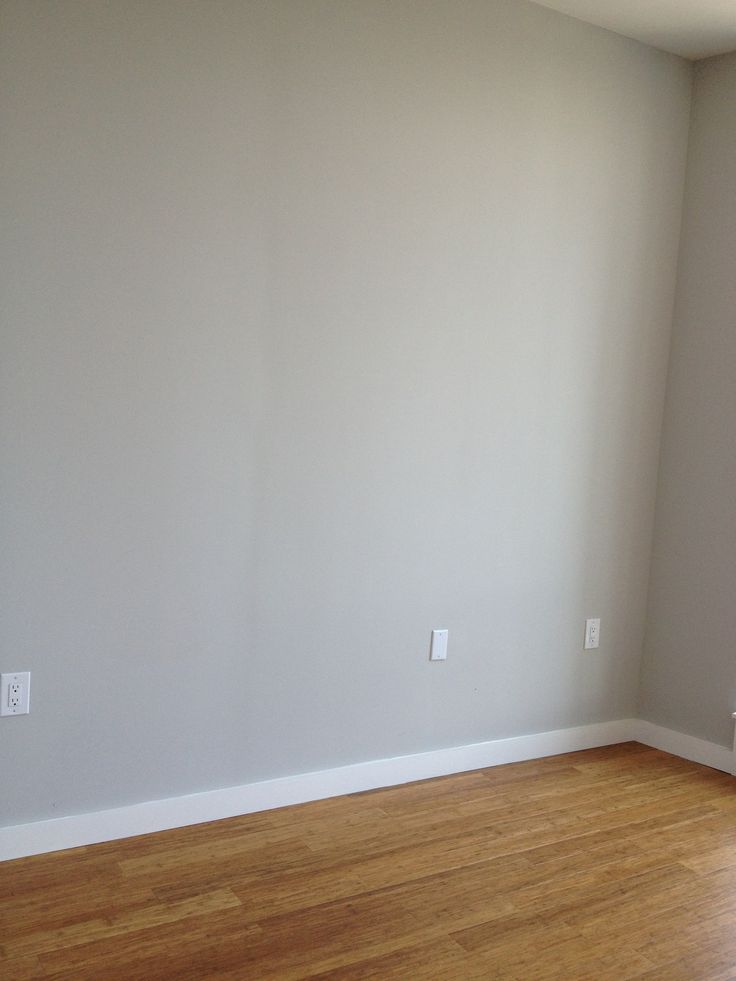 an empty room with hard wood floors and white paint on the walls, is seen in this image