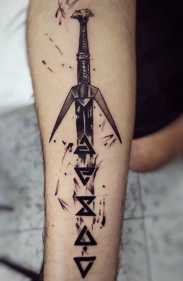 a tattoo on the leg of a man with a knife and letters in black ink