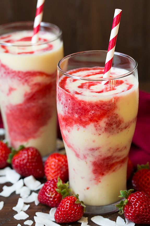 two glasses filled with strawberries on top of a table