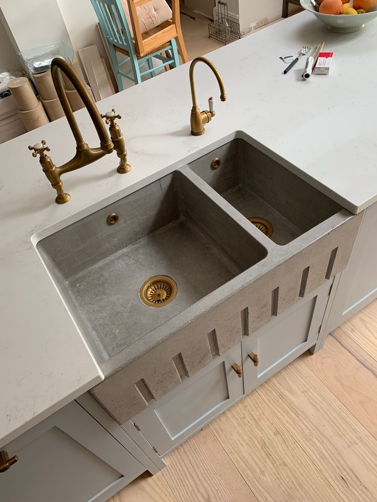 a kitchen sink with two faucets in the middle and an island countertop