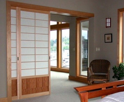 an empty room with sliding glass doors leading to another room and a chair in the corner