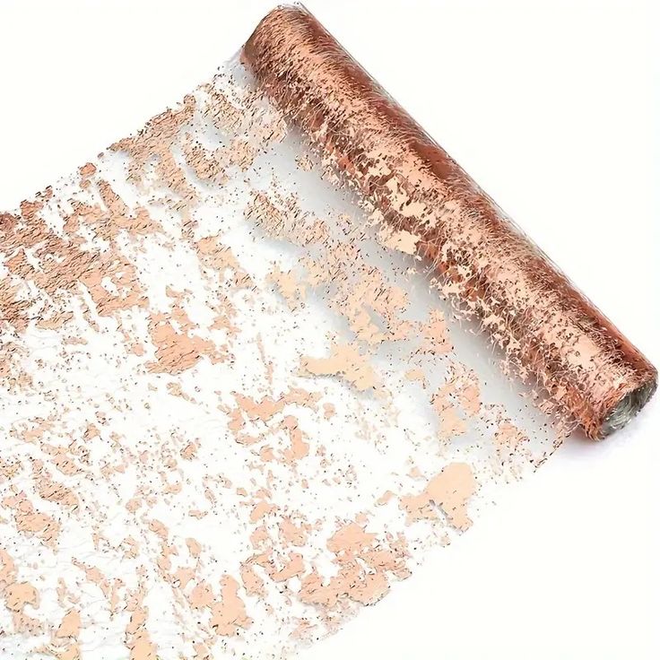 a roll of metallic foil on top of a white surface with gold flecks