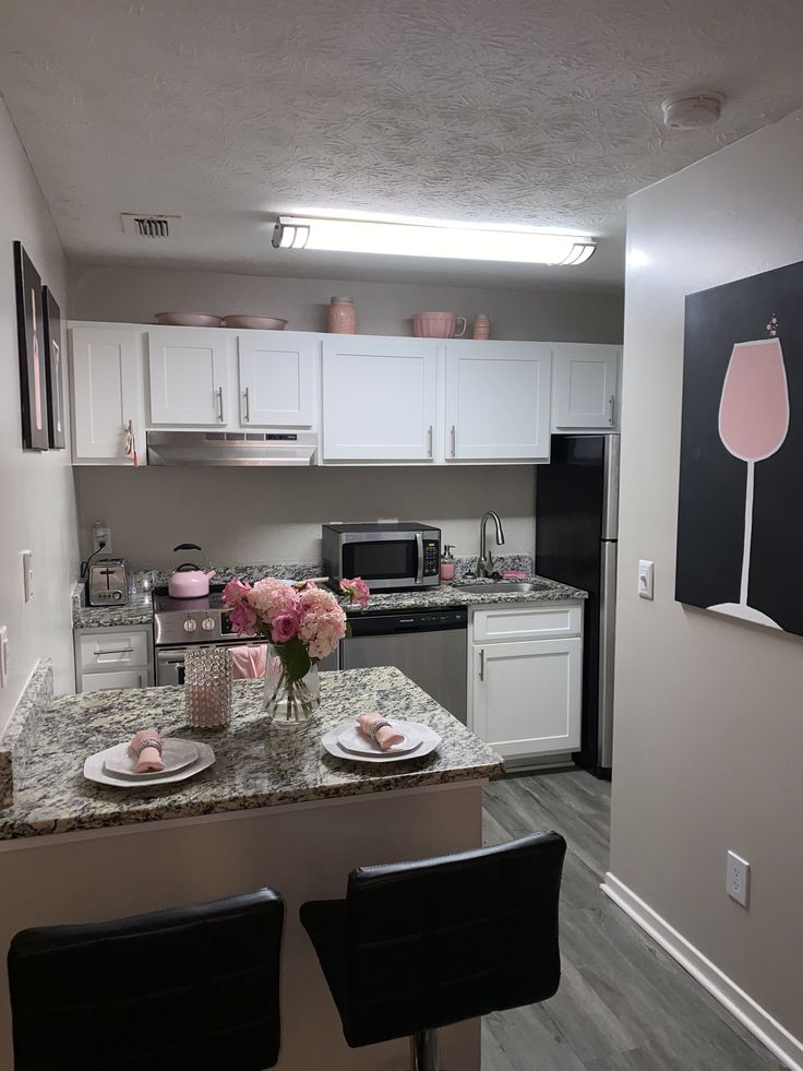 the kitchen is clean and ready to be used for dinner or desserts with pink flowers on the counter