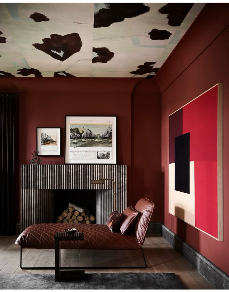 a living room with red walls and leather furniture