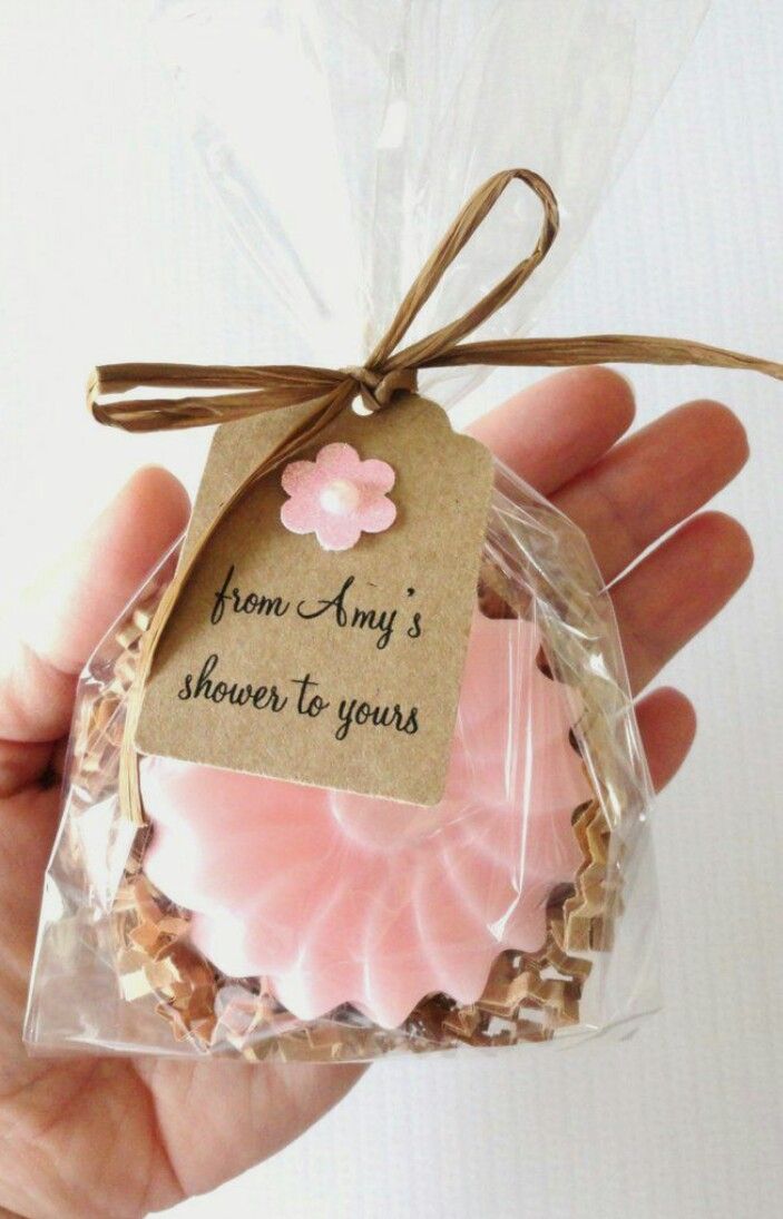 a hand holding a packaged cookie with a tag on it's side and the words from any's shower to yours