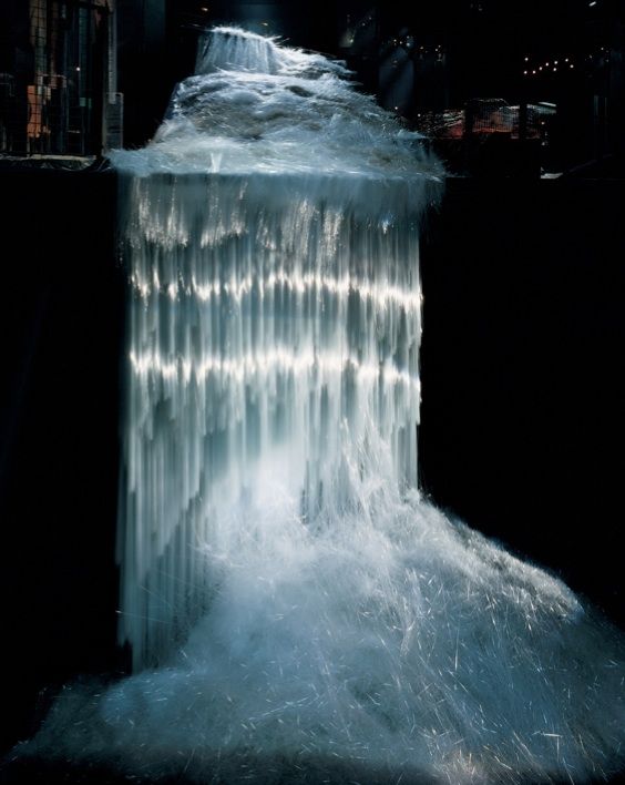 the water is flowing over the edge of the waterfall in the dark night time scene