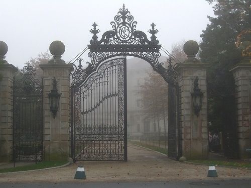 an old iron gate in the middle of a park