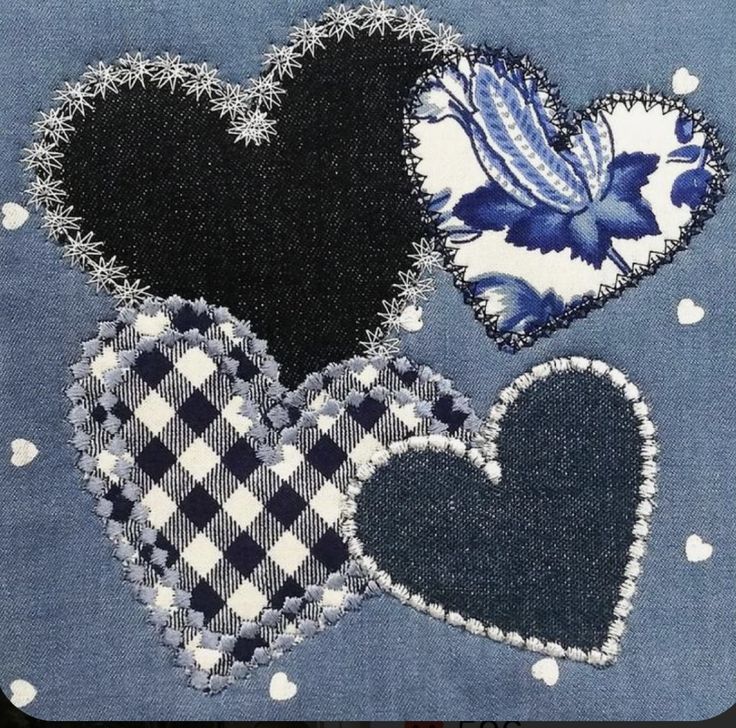 three heart shaped patches sitting on top of a piece of blue fabric with white polka dots