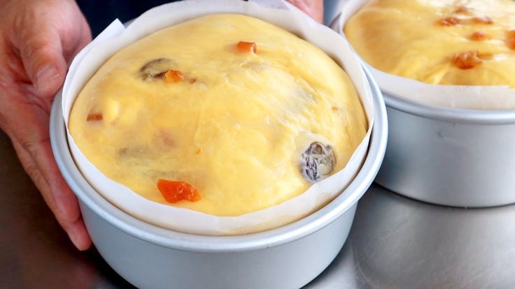 two bowls filled with food sitting on top of a table next to each other in front of a person's hands