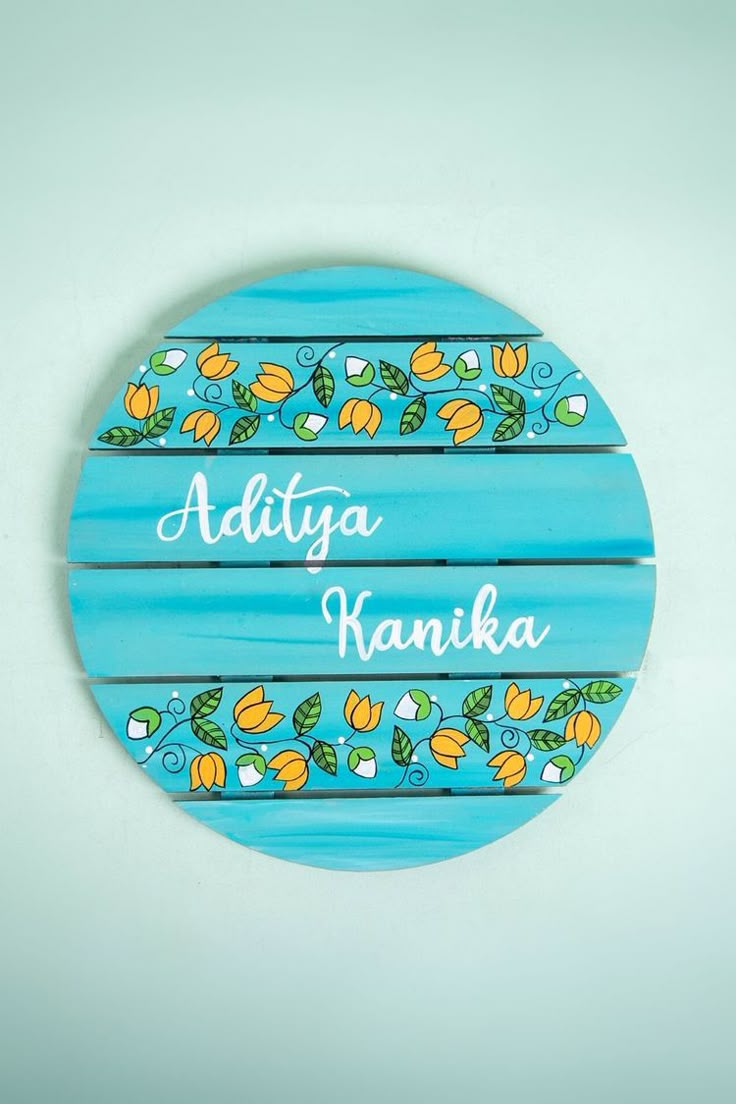 a wooden sign with the name adiya kannika painted on it