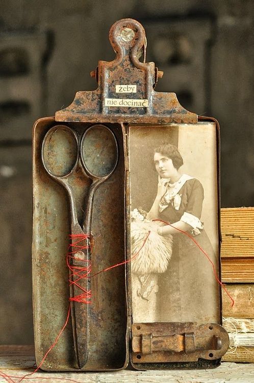 an old pair of scissors sitting in front of a box with a picture on it