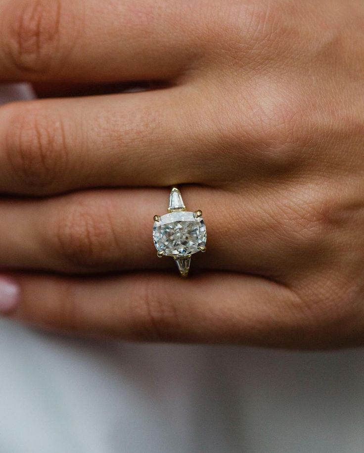 a woman's hand with a diamond ring on it