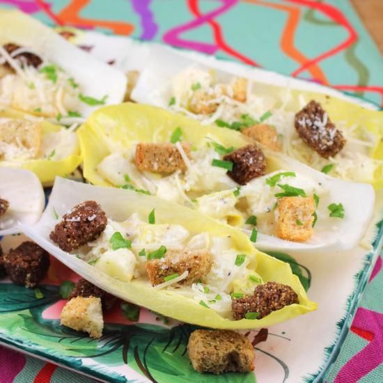 stuffed shells filled with meat and cheese on a colorful tableclothed place mat next to utensils