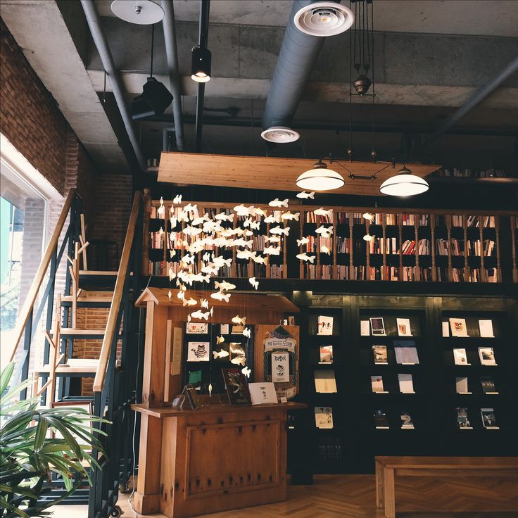 an open book store with books on the shelves and lights hanging from the ceiling above