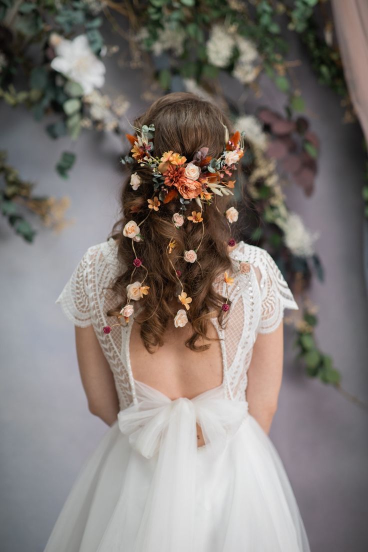 the back of a bride's dress with flowers in her hair