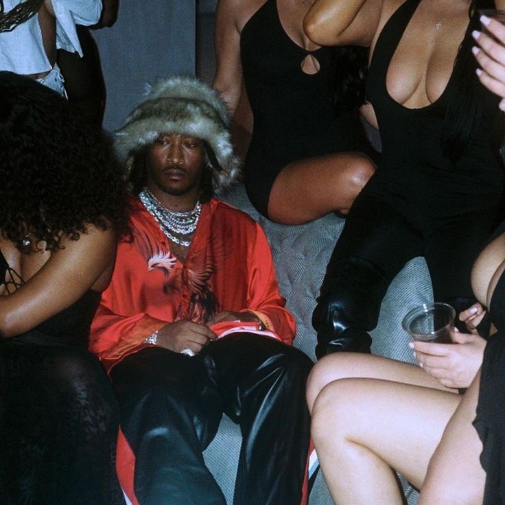 a group of women sitting next to each other in front of a man wearing a fur hat