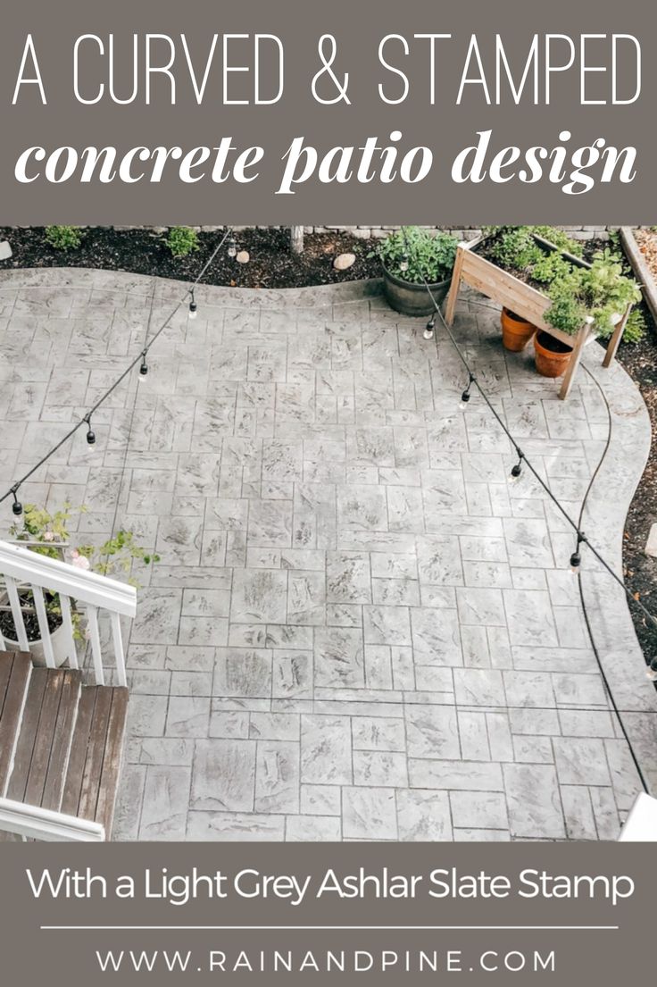 a concrete patio with a white bench and planters