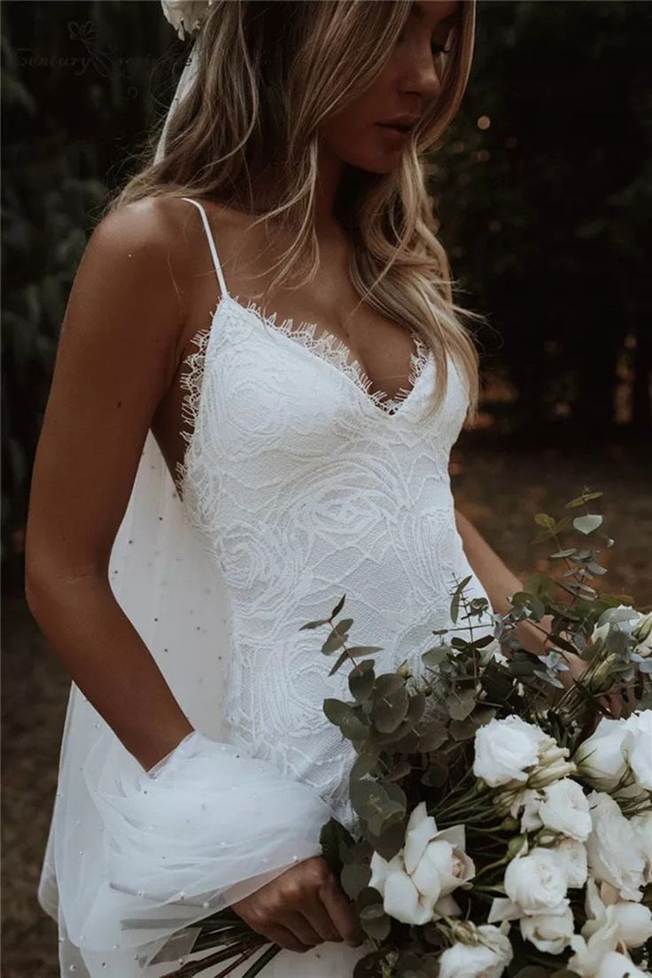 a woman in a white dress holding a bouquet of flowers and wearing a flower crown