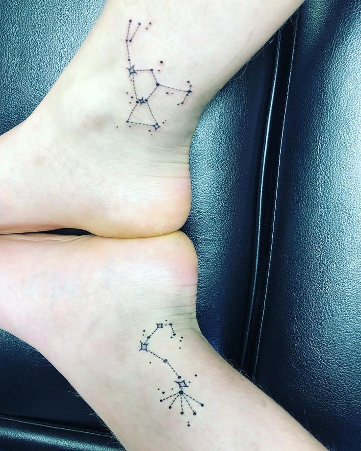 two people with tattoos on their feet sitting next to each other and one has a zodiac sign