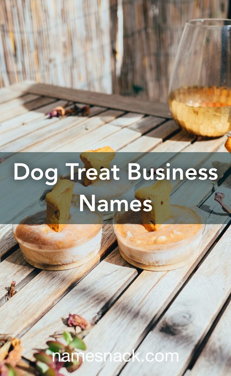 dog treat business names on wooden table next to wine glass and plate with food in it