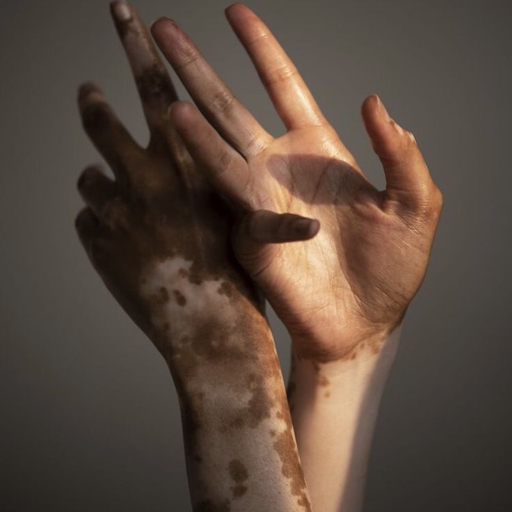 two hands are covered in brown and white paint