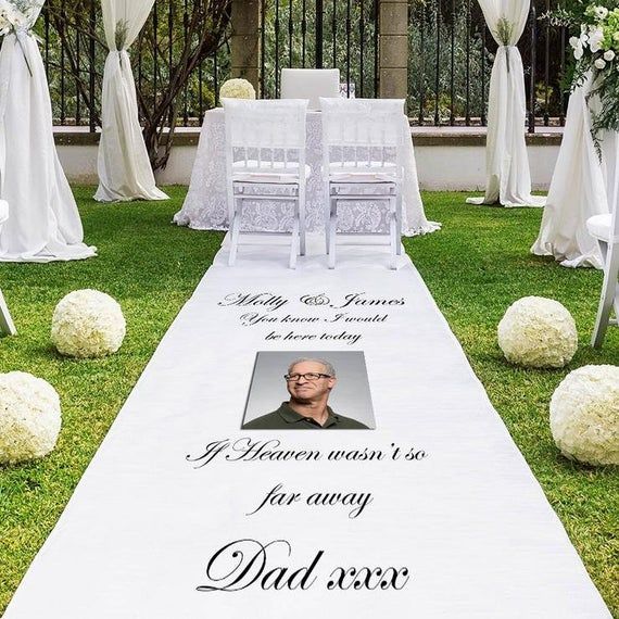 a wedding aisle with white flowers and greenery on the grass is decorated with an image of a man's face