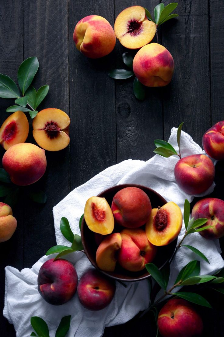 a bowl filled with sliced peaches on top of a table