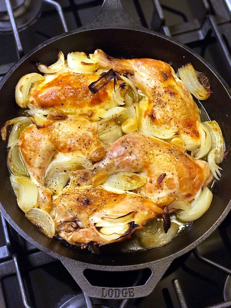 chicken and onions cooking in a skillet on the stove