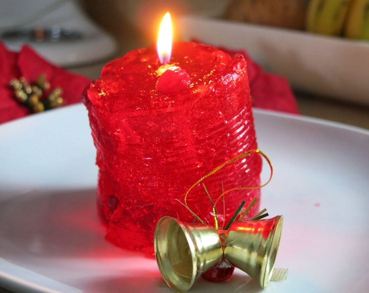 a red candle sitting on top of a white plate