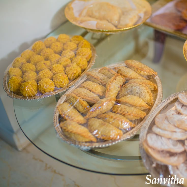 several trays of pastries sitting on top of a glass table