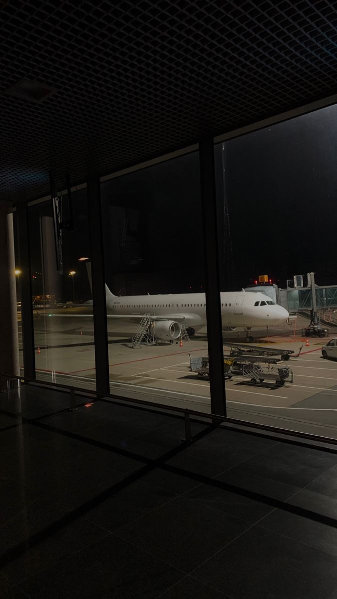 an airplane is parked on the tarmac at night