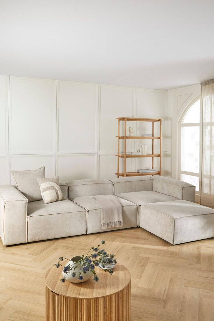 a living room with white furniture and wooden floors