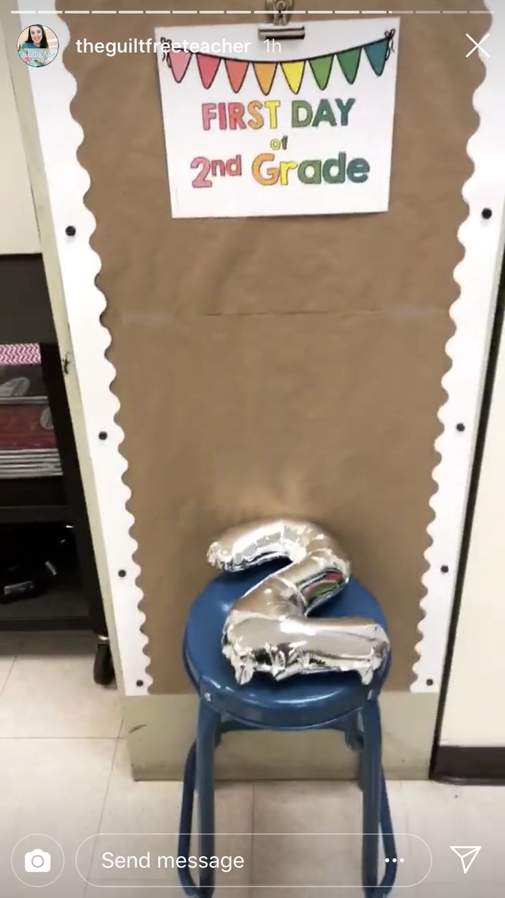 a small blue chair sitting in front of a wall with a first day sign on it