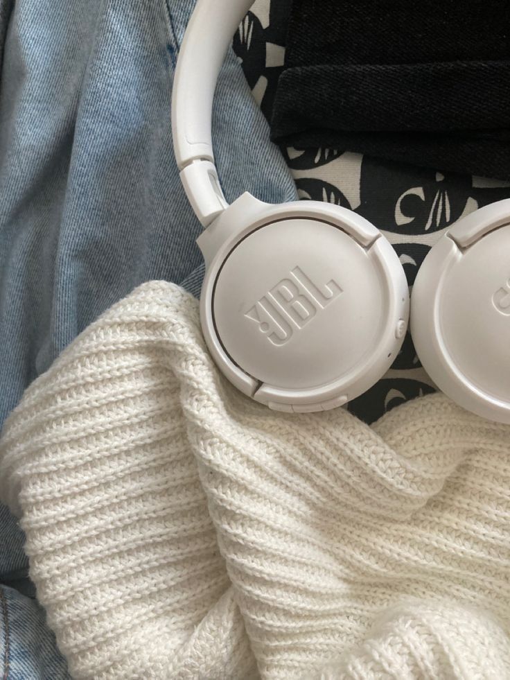 white headphones laying on top of a blanket