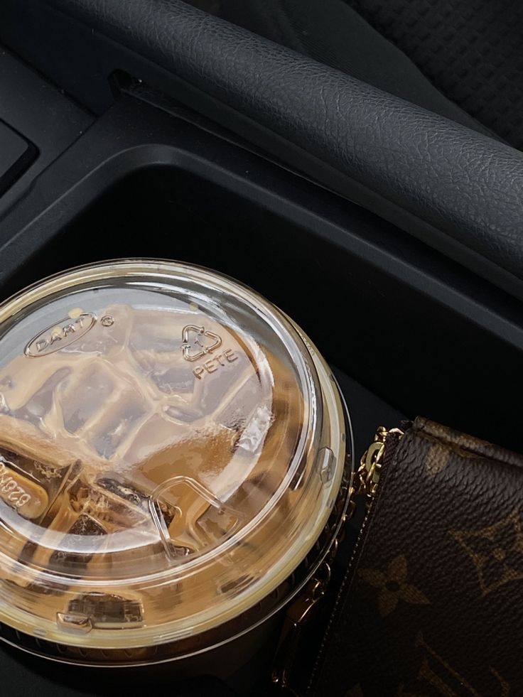 a drink in a plastic cup sitting on top of a brown case