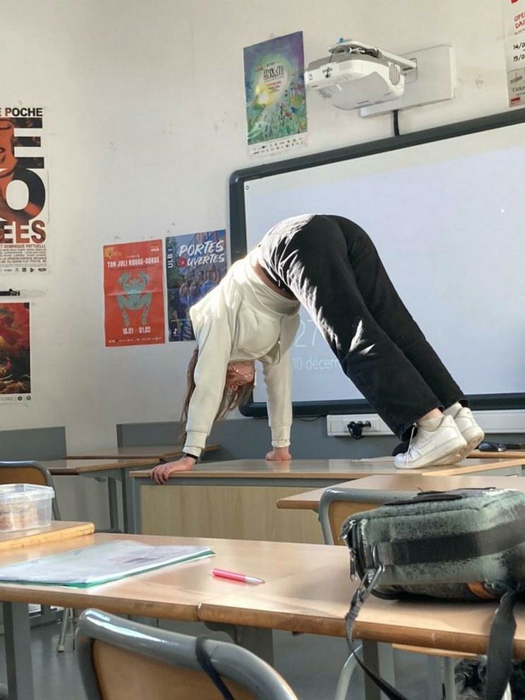 a person doing a handstand in a classroom