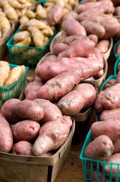 several baskets filled with different types of potatoes