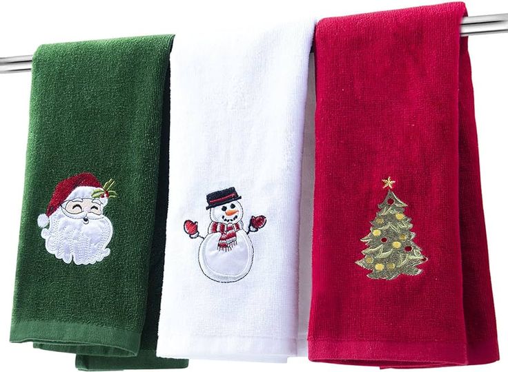 three towels hanging on a clothes line with embroidered santa, snowman and christmas tree