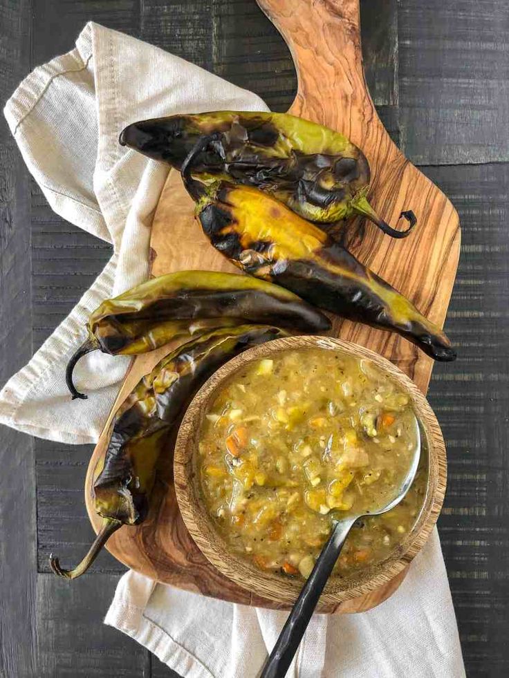 an overhead view of some food on a wooden board with spoons next to it