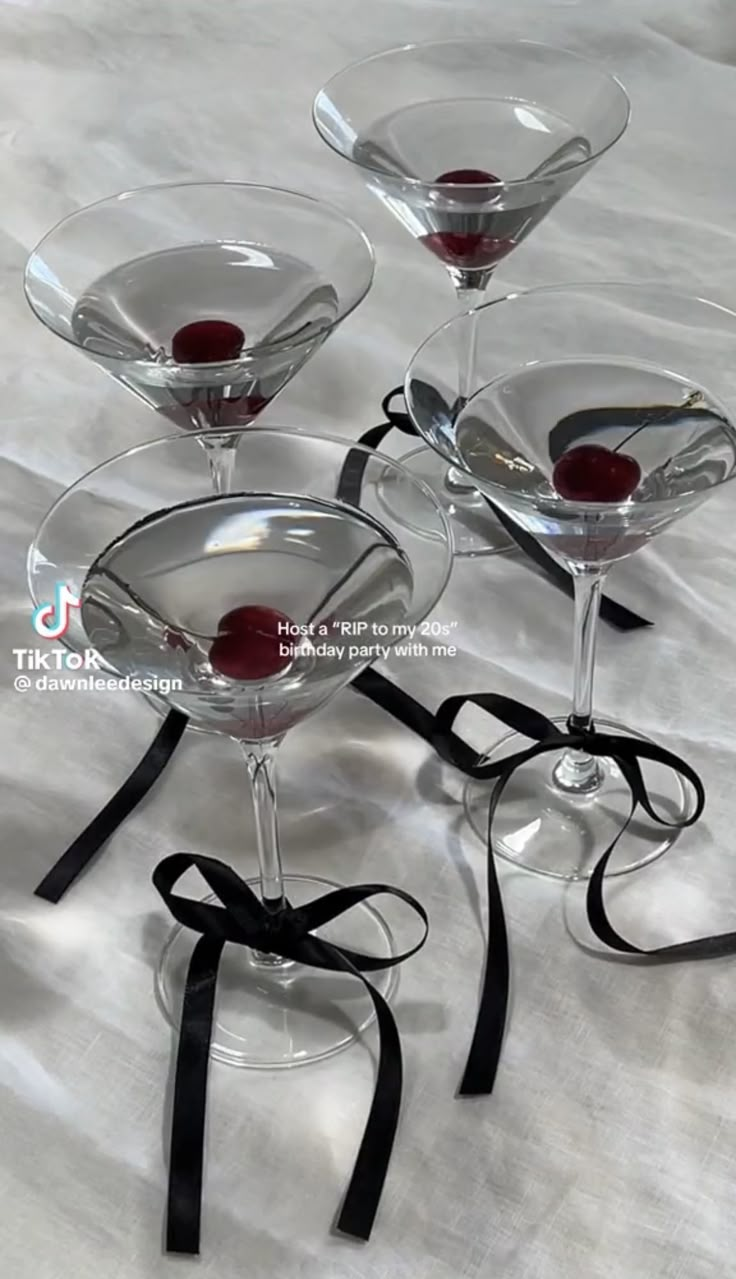 four martini glasses with red wine in them