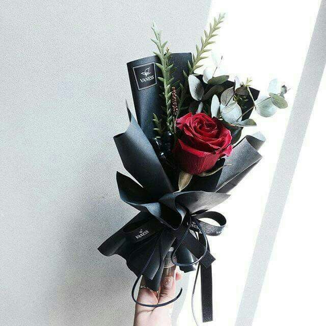 a red rose sitting on top of a black ribbon