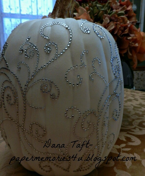 a white pumpkin decorated with beading on it's side sitting on a table