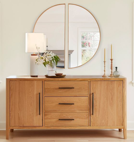 a mirror on top of a wooden dresser