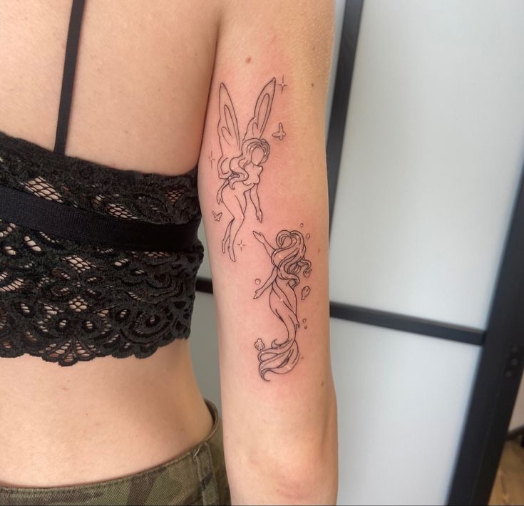 a woman with a tattoo on her arm has a small tinkerbell in it