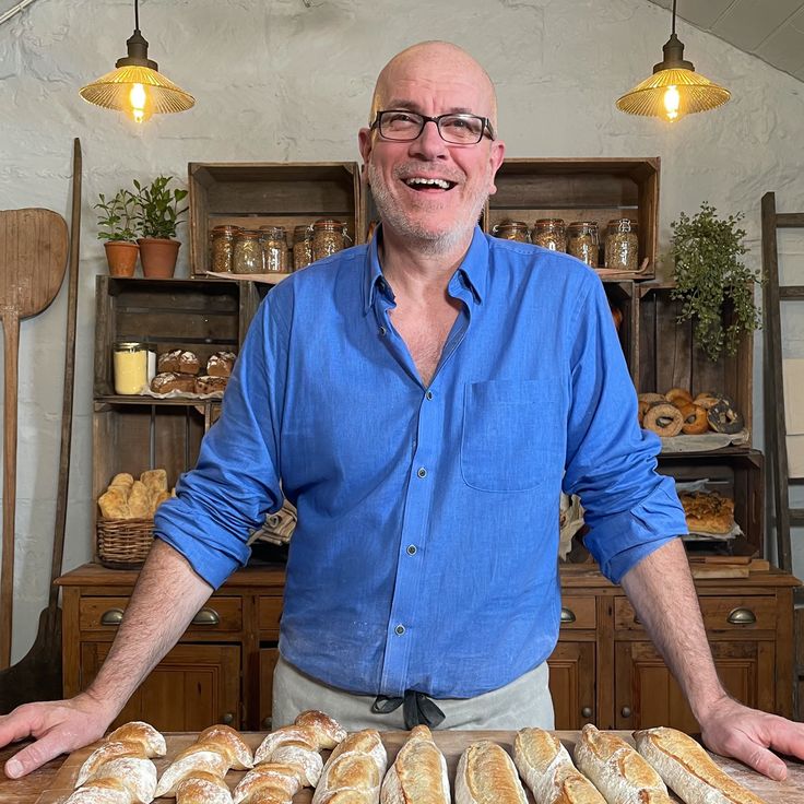 a man standing in front of a table with food on it and smiling at the camera