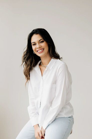 a woman in white shirt and jeans posing for the camera