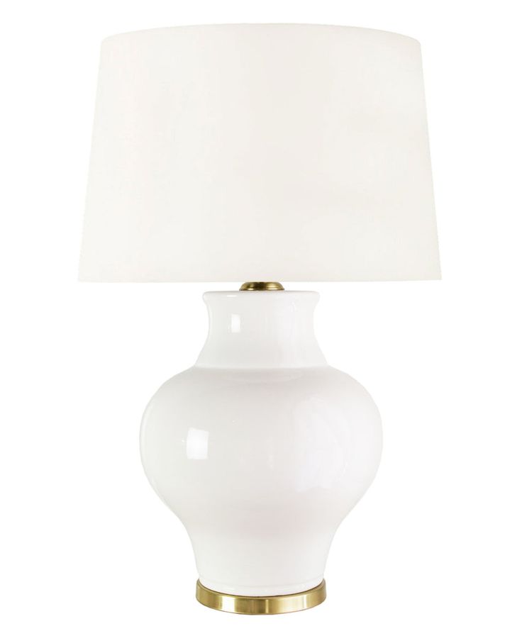 a white table lamp with a gold base and a white linen shade on the top