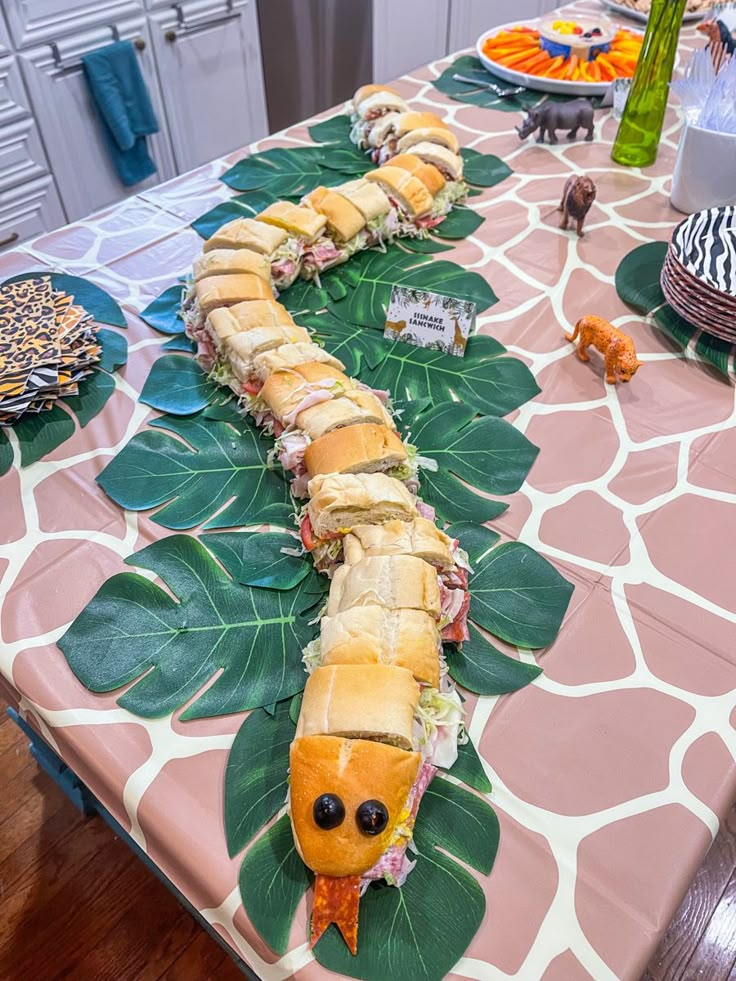 a very long caterpillar sitting on top of a table covered in lots of food