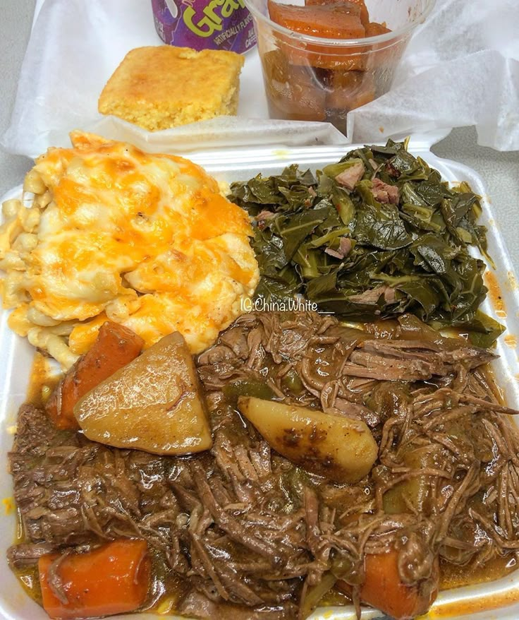 a white plate topped with meat, potatoes and greens next to a cup of coffee