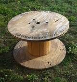 a wooden table sitting on top of a lush green field